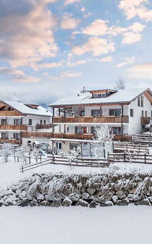 Apartments Fuchsmaurer Snow-covered house framed with fences in the snow